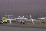 SpaceShipOne, with pilot Brian Binnie at the controls, rolls onto the runway tucked under its White Knight mothership during its second Anasari X Prize flight attempt on Oct. 4, 2004.
