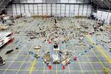 An overview of the Columbia debris reconstruction hangar in 2003 shows the orbiter outline on the floor with some of the 78,760 pieces identified to that date. More than 84,000 pieces of shuttle debris were recovered, some of which is included in a traveling NASA display to stress safety.