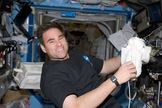 Astronaut Greg Chamitoff, Expedition 17 flight engineer, takes a moment for a photo as he works in the Destiny laboratory of the International Space Station while Space Shuttle Discovery is docked with the station in 2008.