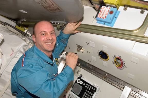 Astronaut Garrett Reisman, Expedition 16/17 flight engineer, poses for a photo after signing the Expedition 16 patch, which was added to the growing collection of insignias representing crews who performed spacewalks from the Quest Airlock of the ISS.
