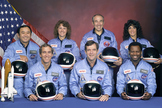 An official portrait shows the STS-51L crewmembers. Back row (L to R): Mission Specialist, Ellison S. Onizuka, Teacher in Space Participant Sharon Christa McAuliffe, Payload Specialist, Greg Jarvis and Mission Specialist, Judy Resnik. Front row (L to R): Pilot Mike Smith, Commander, Dick Scobee and Mission Specialist, Ron McNair.