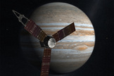 The Juno spacecraft passes in front of Jupiter in this artist's depiction.