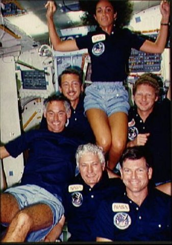 Discovery's first crew, the astronauts of STS 41-D, pose in the middeck for an onboard crew portrait during the shuttle's first flight in 1984.