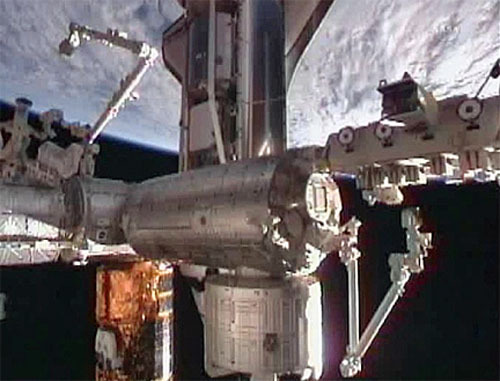 NASA's space shuttle Discovery is shown docked to the International Space Station shortly after arriving on Feb. 26, 2011. The gold spacecraft at the bottom of this view is Japan's HTV-2 spacecraft.