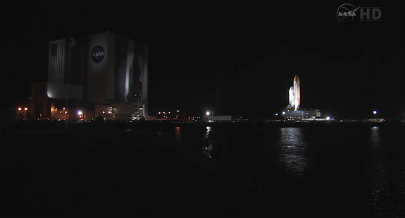 The space shuttle Endeavour casts a shadow on NASA's enormous Vehicle Assembly Building as it rolls to the launch pad for its final mission STS-134 on March 10, 2011 at the Kennedy Space Center in Florida. Endeavour is slated to launch on the mission on April 19.