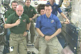 NASA astronaut Scott Kelly (left) hands over command of the International Space Station to cosmonaut Dmitry Kondratyev (right) during a ceremony on March 14, 2010.