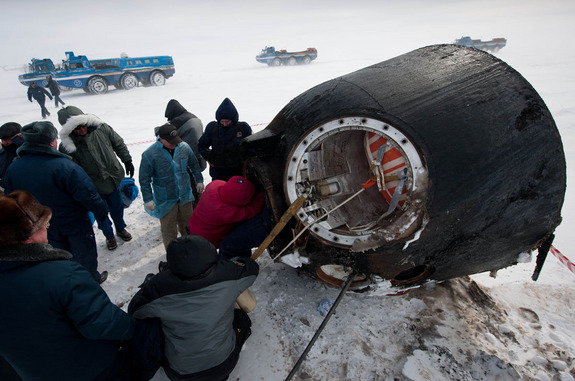 Russian support personnel work to help get crew members out of the Soyuz TMA-01M spacecraft shortly after the capsule landed with Expedition 26 Commander Scott Kelly and Flight Engineers Oleg Skripochka and Alexander Kaleri near the town of Arkalyk, Kazakhstan on Wednesday, March 16, 2011.