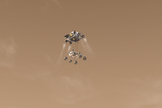 This artist's concept depicts the Curiosity rover as it is being lowered by a rocket-powered descent stage during a critical moment of the "Sky Crane" landing in 2012.