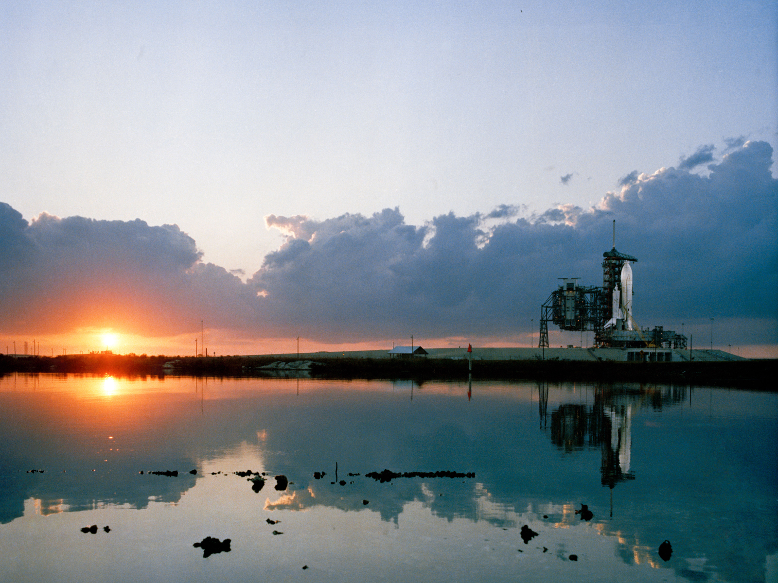 The sun rises over Kennedy Space Center as space shuttle Columbia awaits the start of STS-1, the first space shuttle mission, which launched on April 12, 1981.