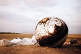 Here the re-entry capsule of the Vostok 3KA-3 (also known as Vostok 1) spacecraft (Vostok 1) is seen with charring and its parachute on the ground after landing south west of Engels, in the Saratov region of southern Russia.