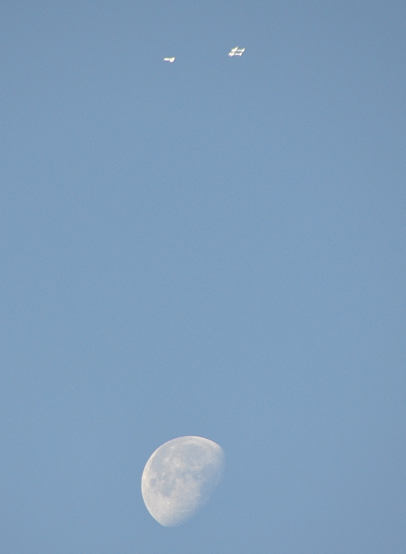 Virgin Galactic's SpaceShipTwo passenger spacecraft and its WhiteKnightTwo carrier plane are seen flying with the moon below during an April 22, 2011 glide test over the Mojave Air and Space Port in California.