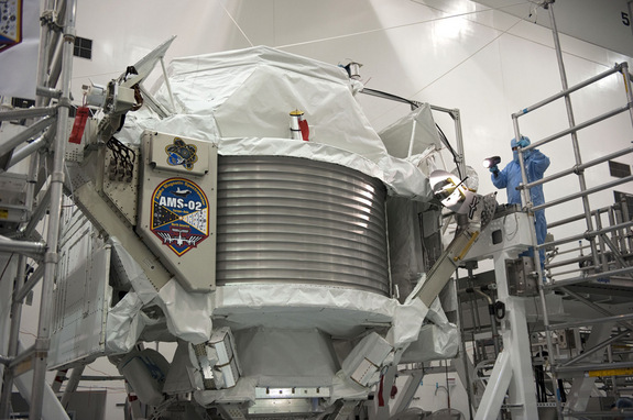 Technicians examine the $2 billion Alpha Magnetic Spectrometer instrument in a work stand ahead of its planned launch on NASA's space shuttle Endeavour. The AMS instrument will search for cosmic rays from the International Space Station.