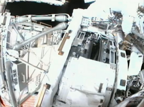 This view from a spacewalker helmet camera shows the International Space Station's port side Solar Alpha Rotary Joint (gear in center), a huge gear that turns the station's port solar arrays, during a May 22, 2011 spacewalk by astronauts Andrew Feustel and Mike Fincke.