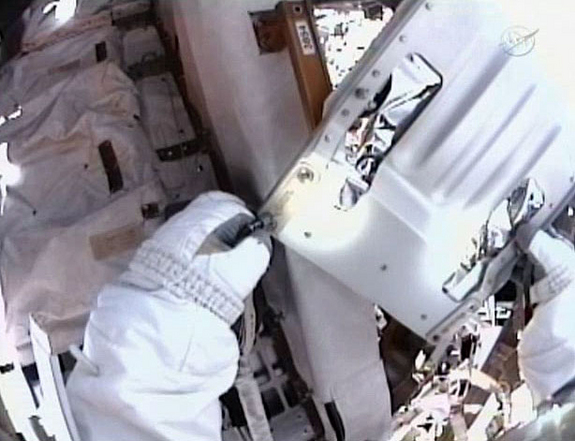 This still from a video taken by the spacesuit helmet camera of astronaut Mike Fincke shows one of four loose bolts he caught as they floated free of the International Space Station during a May 22, 2011 spacewalk to grease up a solar array gear.
