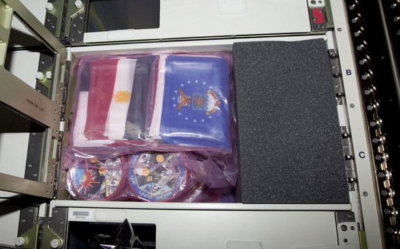 arious U.S., military and country flags, as well as assorted space shuttle mission patches are among the mementos packed aboard Atlantis for the final space shuttle mission.