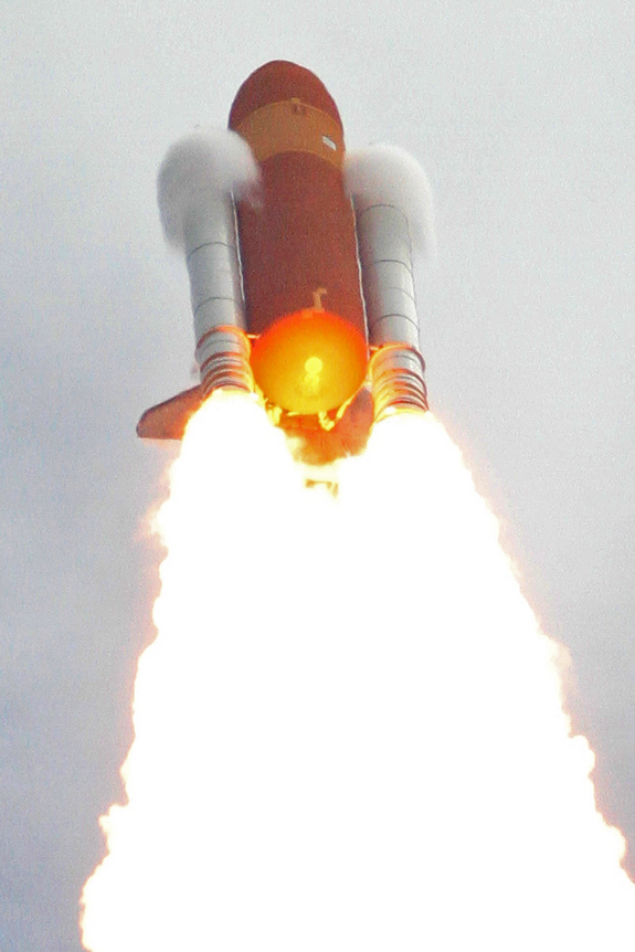 This view of vapor clouds forming atop the twin solid-rocket boosters as the shuttle Atlantis and its launch stack approached the speed of sound was captured from behind the countdown clock using a Canon EOS 7D digital SLR camera coupled to a Takahashi FS-78 apochromatic refractor on July 8, 2011.