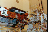 Kennedy Space Center (KSC) technicians, wearing clean suits, prepare the Upper Atmosphere Research Satellite (UARS) for the installation of the high-gain antenna on the instrument module.