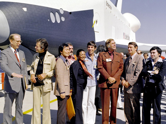 In 1976, NASA's space shuttle Enterprise rolled out of the Palmdale manufacturing facilities and was greeted by NASA officials and cast members from the 'Star Trek' television series. From left to right they are: NASA Administrator Dr. James D. Fletcher; DeForest Kelley, who portrayed Dr. "Bones" McCoy on the series; George Takei (Mr. Sulu); James Doohan (Chief Engineer Montgomery "Scotty" Scott); Nichelle Nichols (Lt. Uhura); Leonard Nimoy (Mr. Spock); series creator Gene Roddenberry; an unnamed NASA official; and, Walter Koenig (Ensign Pavel Chekov).