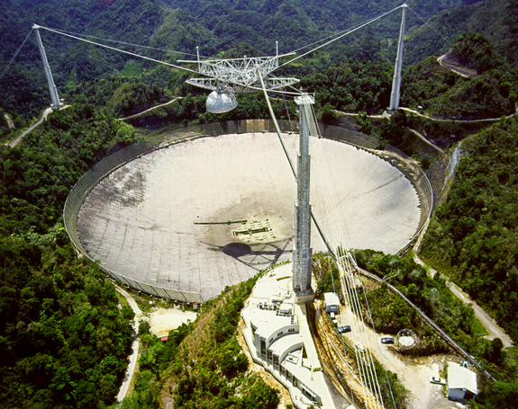 Astronomers use the huge Arecibo Observatory, a radio telescope in Puerto Rico, to study the close flyby of Earth by asteroids.