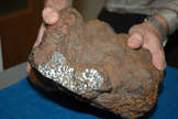 The rusting fusion crust on the outside of the Conception Junction meteorite disguises it as just another rock, but one glimpse of the interior gives the game away. The olive-green crystals set in lustrous metal are unique to pallasites.