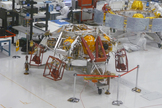 A zoomed-in view shows the rocket-powered sky crane (foreground) that will lower NASA's Curiosity rover to the Martian surface. In the background, technicians work on the cruise stage that will get Curiosity to the Red Planet. This photo was taken in May 2011 at NASA's Jet Propulsion Lab in Pasadena, Calif.