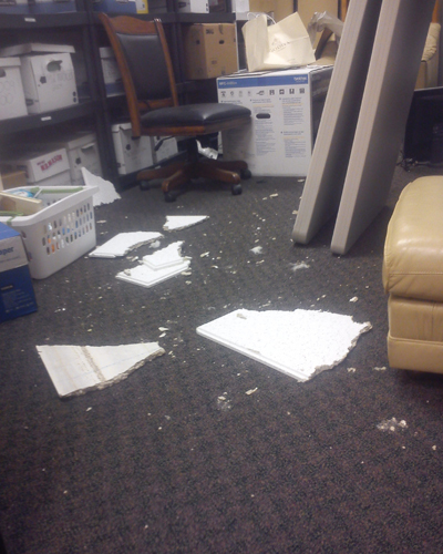 Broken ceiling tiles on the floor of the warehouse. The FAA confiscated the piece of debris before workers could take a picture of it, one employee said.