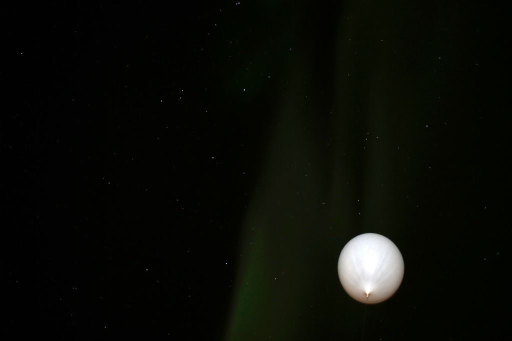 Weather Balloon Rising into Alaska's Aurora