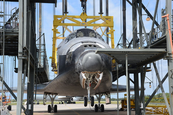Space shuttle Discovery, suspended in Kennedy Space Center's Mate-Demate Device, was delayed a day being lifted atop its jumbo jet ride to the Smithsonian due to winds on April 14, 2012.