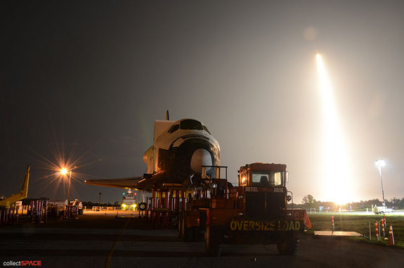 SpaceX's first space station-bound Dragon spacecraft, flying atop a Falcon 9 rocket, launches behind a high fidelity mockup of the space shuttle, NASA's previous means of delivering cargo to International Space Station. Liftoff occurred on May 22, 2012 from Cape Canaveral Air Force Station.