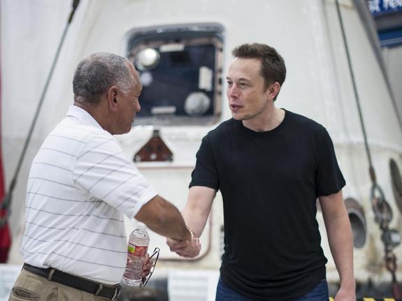 NASA administrator Charles Bolden (left) congratulates SpaceX CEO and chief designer Elon Musk on June 13, 2012. Behind them is the Dragon capsule that on May 25 became the first private vehicle ever to dock with the International Space Station.