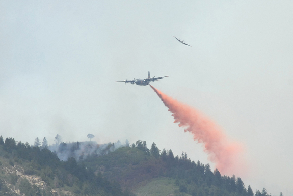 A U.S. Forest Service aircraft breaks away, top, as a Modular Airborne Firefighting System-equipped C-130 aircraft begins dropping flame retardant on a section of the Waldo Canyon fire near Colorado Springs, Colo., on June 26, 2012.