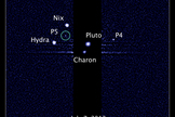 This image, taken by NASA's Hubble Space Telescope, shows five moons orbiting the distant, icy dwarf planet Pluto. The green circle marks the newly discovered moon, designated P5, as photographed by Hubble's Wide Field Camera 3 on July 7, 2012.