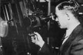 Clyde Tombaugh, discoverer of Pluto, peers into an instrument.
