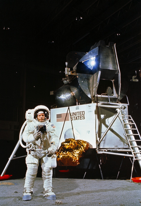 Astronaut Neil A. Armstrong, wearing an Extravehicular Mobility Unit, participates in a simulation of deploying and using lunar tools on the surface of the moon during a training exercise in Building 9 on April 22, 1969. Armstrong is the commander of the Apollo 11 lunar landing mission. In the background is a Lunar Module mock-up.