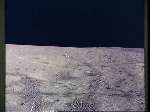 The javelin and golf ball used by Alan B. Shepard Jr. during Apollo 14's lunar mission lie left of center. The golf ball is just below the javelin, almost perpendicular to it.