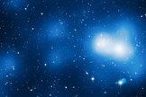 This enormous image shows Hubble’s view of massive galaxy cluster MACS J0717. The large field of view is a combination of 18 separate Hubble images. The location of the dark matter is revealed in a map of the mass in the cluster and surrounding region, shown here in blue. The filament visibly extends out and to the left of the cluster core.