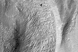 Closeup view shows chevron texture on riverbed floor, indicating how the ice-rich material flowed fastest in the middle and was retarded along the channel walls.