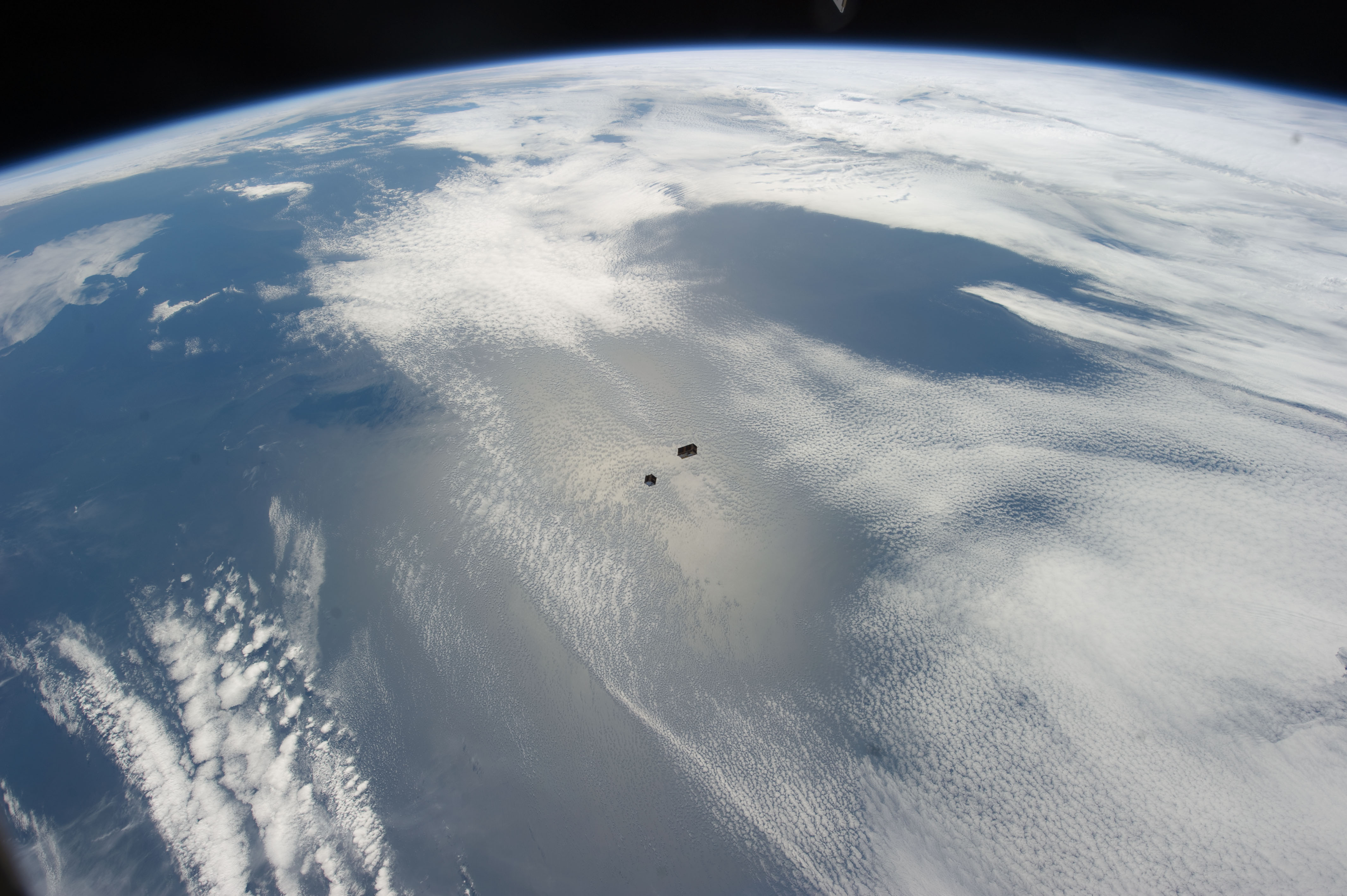Tiny Cubesat Satellites Over Earth