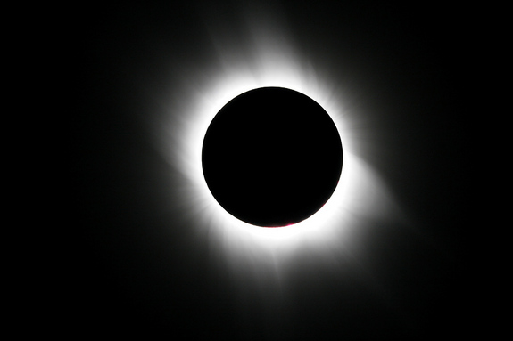 The sun’s outer atmosphere, or corona, on March 29, 2006 was surprisingly full of structure even though the sun then was at its minimum activity. The corona displayed at least six long, beautiful streamers that extended almost symmetrically in opposite directions, like a bow tie or pair of butterfly wings, before tapering off into the deep, velvety-blue sky. Note how the prominent hairlike brushes delicately traced magnetic-field lines above the sun’s polar regions.