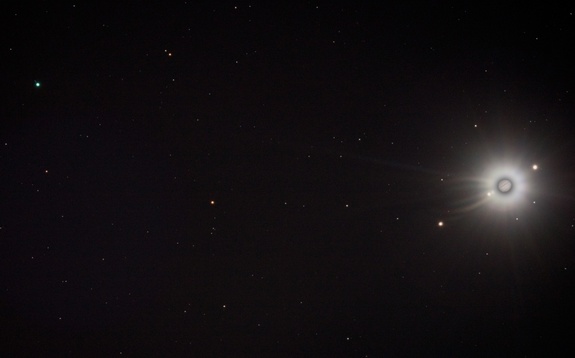 In late September 2010, Jupiter, on the right, and Uranus, on the left, were opposite the sun in Earth's sky. Of the tilted planet's five larger moons, two — Oberon and Titania — can be seen just above and left of the planet's disk. At the right side of the frame is ruling gas giant Jupiter, flanked along a line by all four of its Galilean satellites. Farthest from Jupiter is Callisto, with Europa and Io all left of the planet's disk, while Ganymede stands alone at the right.