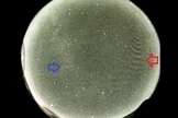 The red arrow points to the unidentified low-intensity wave pattern, which the researchers suspect is an auroral-generated wave interaction with airglow. For contrast, the blue arrow points to the faint emission of the Milky Way.
