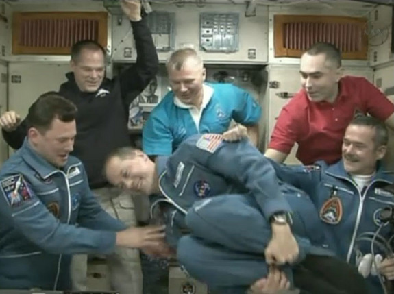 NASA astronaut Tom Marshburn does a flip in zero-g after arriving at the International Space Station Dec. 21. He, Russian cosmonaut Roman Romanenko, and Canadian astronaut Chris Hadfield had just docked aboard a Russian Soyuz spacecraft to join the existing Expedition 34 crewmembers, above.