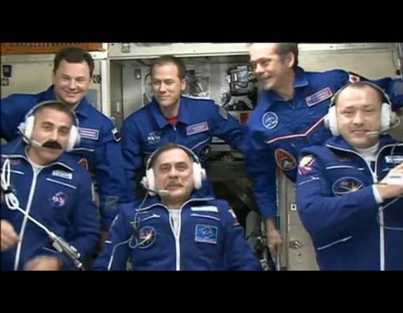 NASA astronaut Chris Cassidy (bottom left) wears a felt mustache to match the Canadian astronaut Chris Hadfield on board the International Space Station