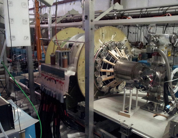 The fusion driven rocket test chamber at the UW Plasma Dynamics Lab in Redmond. The green vacuum chamber is surrounded by two large, high-strength aluminum magnets. These magnets are powered by energy-storage capacitors through the many cables connected to them. Image added April 10, 2013.