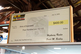 The oversized check by the Nevada & California-based radio station The Highway, used to finally pay a $400 litter fine after 30 years, is on display above the case.