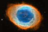 This close-up, visible-light view by NASA's Hubble Space Telescope reveals new details of the Ring Nebula. The object is tilted toward Earth so that astronomers see the ring face-on. The Hubble observations reveal that the nebula's shape is more complicated than astronomers thought. The blue gas in the nebula's center is actually a football-shaped structure that pierces the red doughnut-shaped material. Image released May 23, 2013.