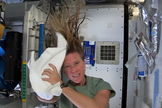 To wash her hair in space, astronaut Karen Nyberg uses a towel first to help add no-rinse shampoo to her hair, then to dry her hair in this still from a video recorded on the International Space Station and posted online on July 9, 2013. Reusing towels is vital since there is a limited supply, she says.