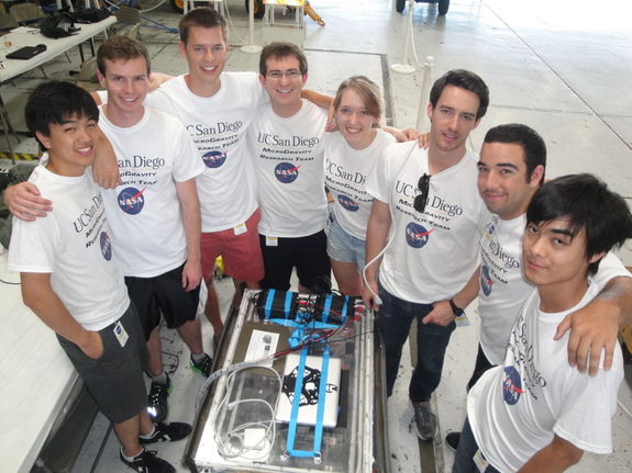 Engineering students with the UCSD Microgravity Team from the University of California, San Diego, stands near their biofuel experiment to test weightless flames ahead of a NASA Microgravity University flight at Ellington Field in Houston. The are: (clockwise from left): Joshua Siu, Sam Avery, Jack Goodwin, Andrew Beeler, Daneesha Kenyon, Joshua Sullivan, Nico Montoya, and Victor Hong. NASA mentor Christina Gallegos is not pictured. Image taken on July 18, 2013.