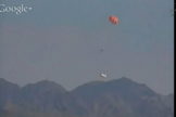 The Orion capsule falls closer to the ground with parachutes deployed at Yuma Proving Ground, Arizona, on July 24, 2013.