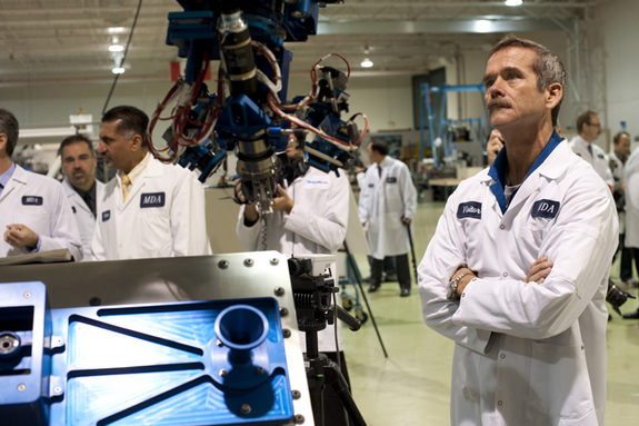 Canadian Astronaut Chris Hadfield looks on at a demonstration of the Next-Generation Canadarm Small Canadarm prototype during a visit to the NGC prime contractor, MDA of Brampton, Ontario, in September 2012.